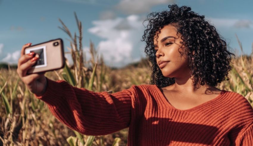 A woman taking a selfie in a corn field.