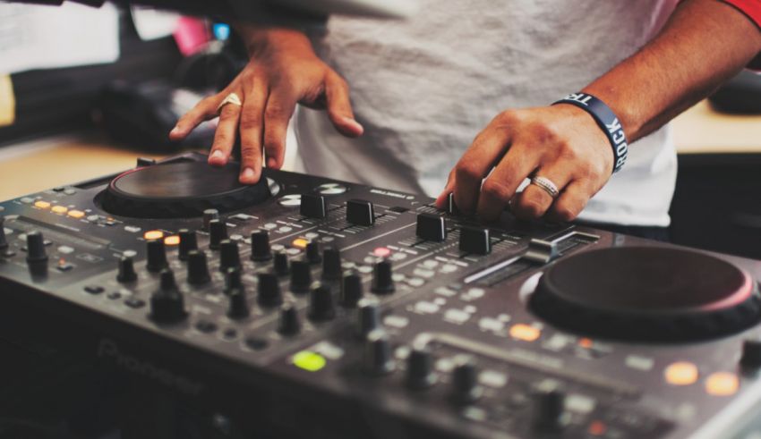 A dj is mixing music on a dj mixer.