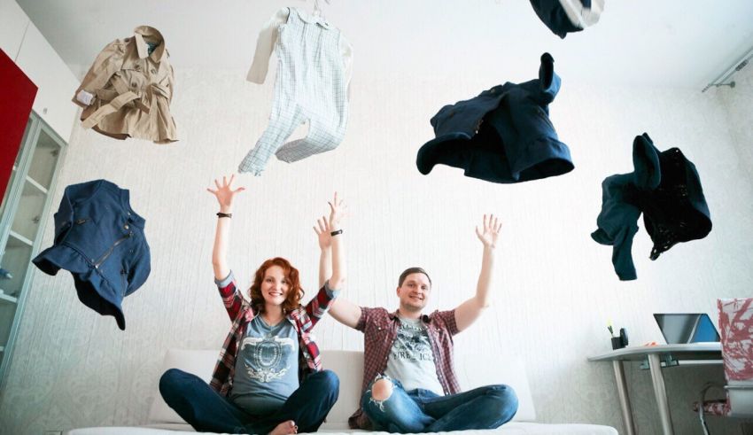 A man and woman in a room with clothes flying in the air.