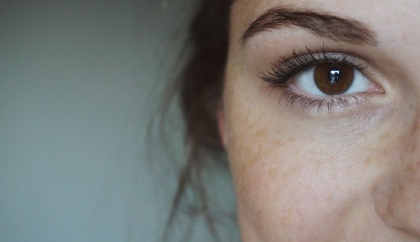 A close up of a woman's eye with freckles.
