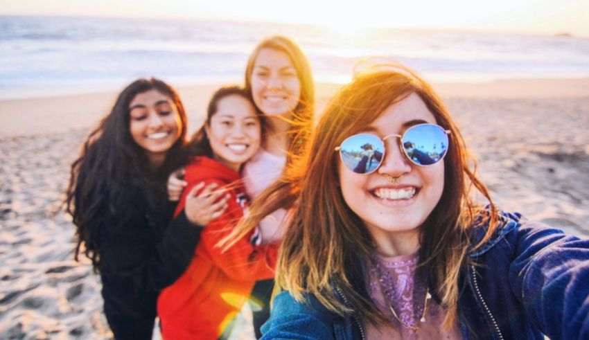 A group of friends taking a selfie on the beach.