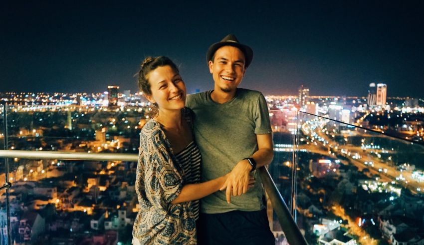 A couple posing on top of a building at night.