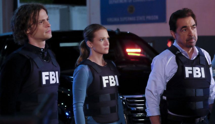 Three fbi agents standing in front of a car.