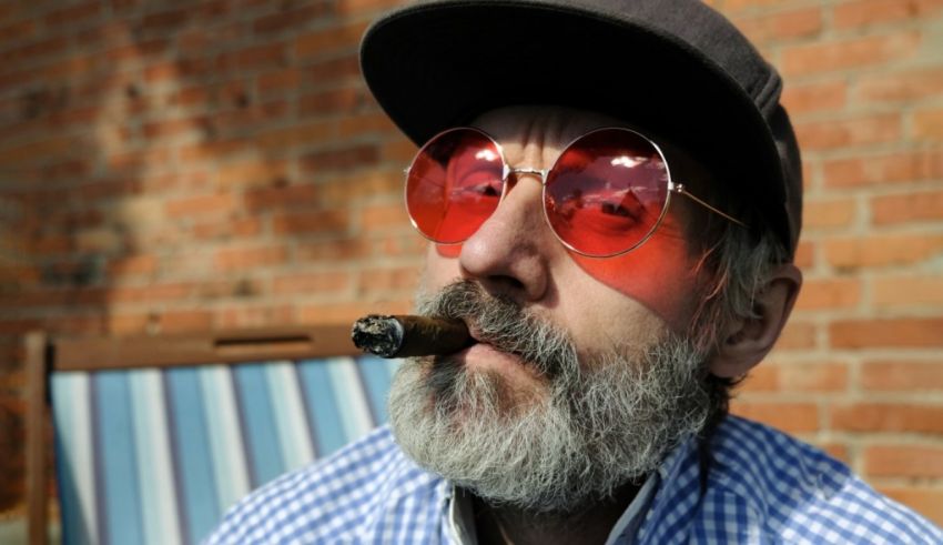 A man with a beard smoking a cigar.