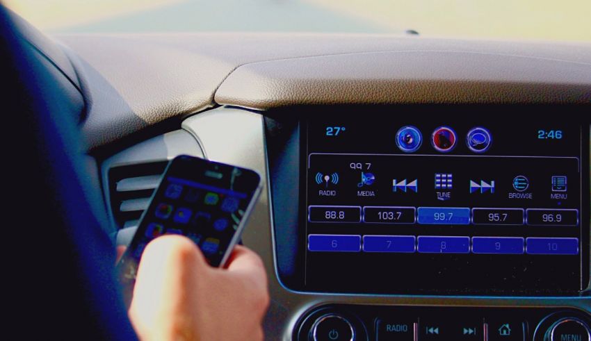 A person holding a cell phone in a car.