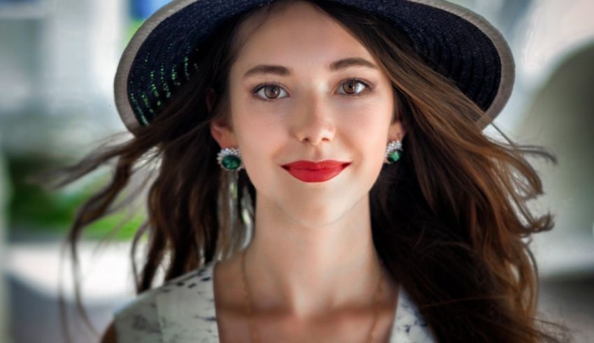 A young woman wearing a hat and red lipstick.