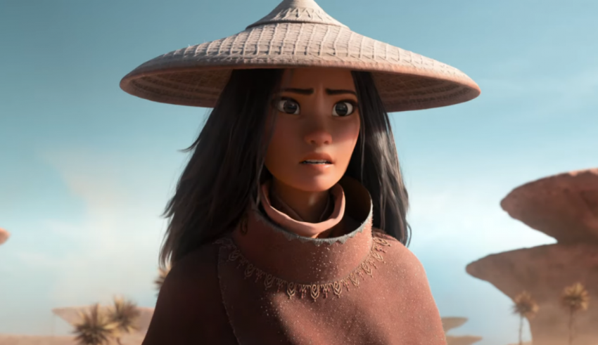 A woman in a hat is standing in a desert.