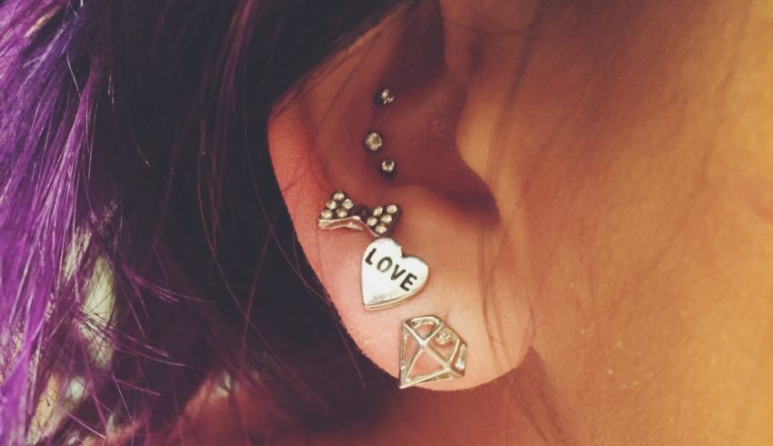 A woman with purple hair wearing ear piercings.