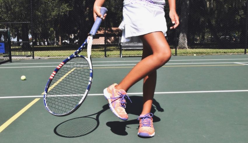 A girl holding a tennis racket on a tennis court.