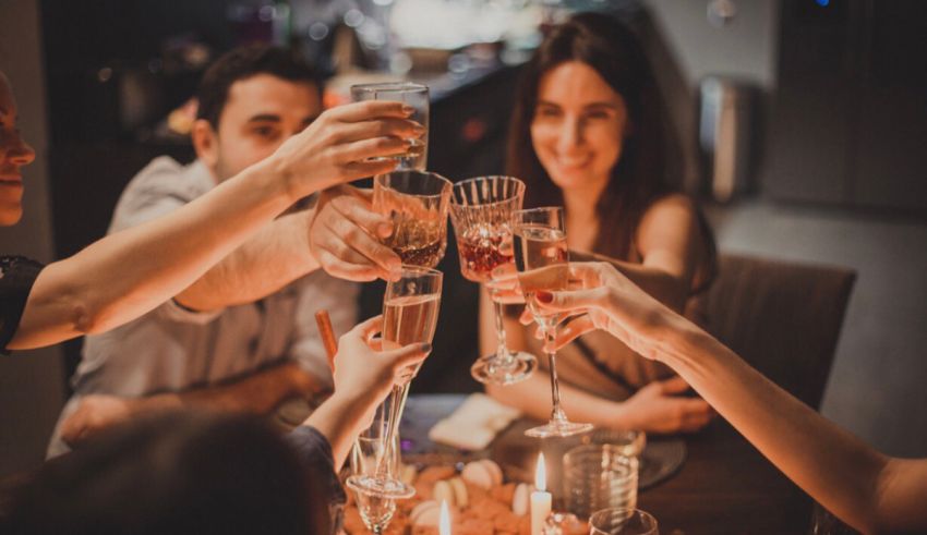 A group of friends toasting wine glasses at a dinner party.