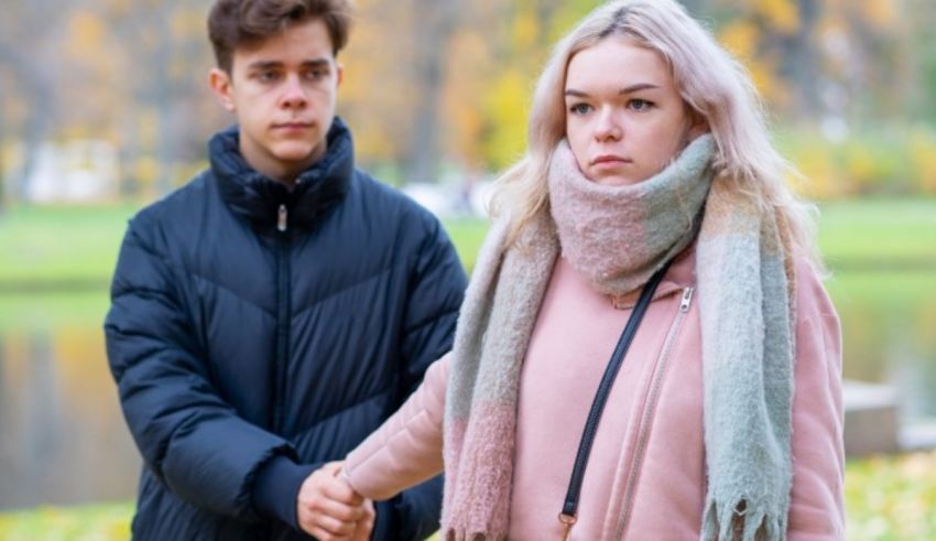 A man and a woman holding hands in a park.