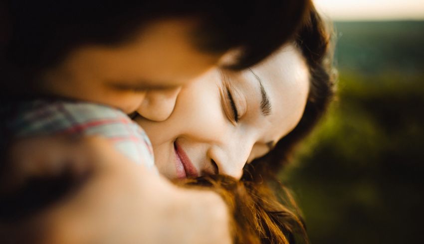 A man and woman hugging each other in the middle of a field.