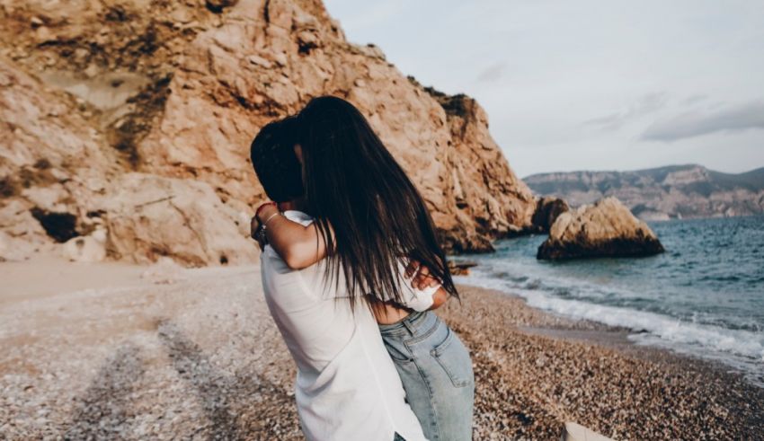 A couple hugging on the beach.