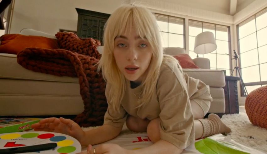 A girl laying on the floor playing with a game.