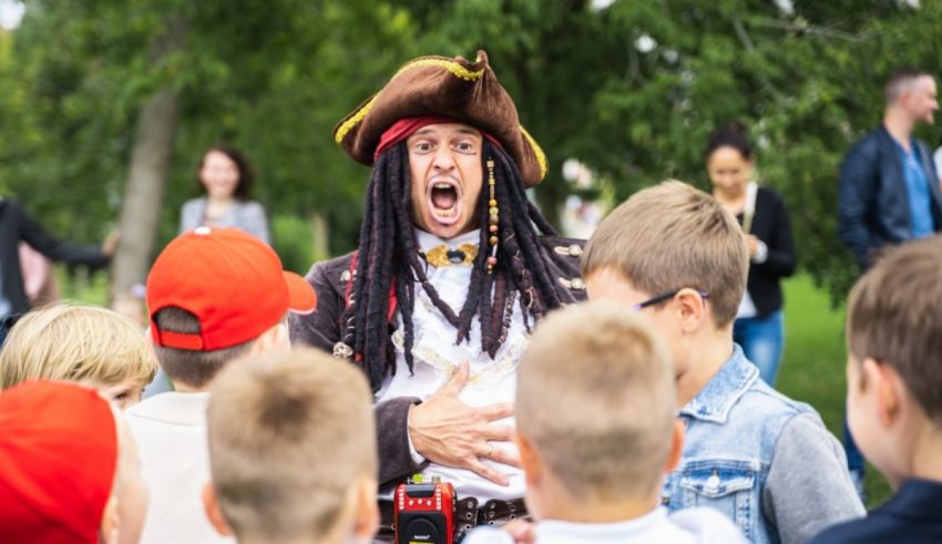 A man dressed as a pirate in front of a crowd of children.
