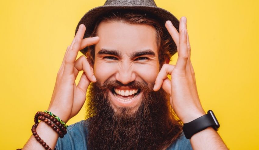 A bearded man with a hat and a beard on a yellow background.