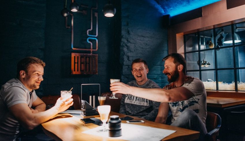 Three men drinking beer at a bar.