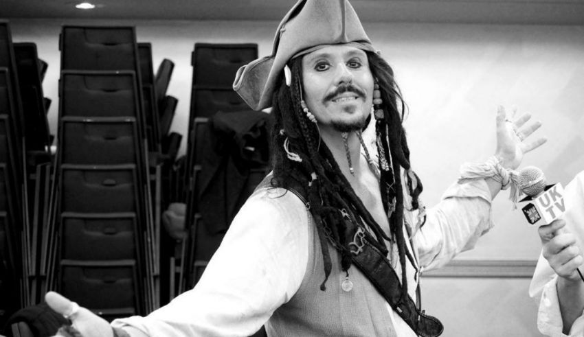 A man in a pirate costume is holding a microphone.