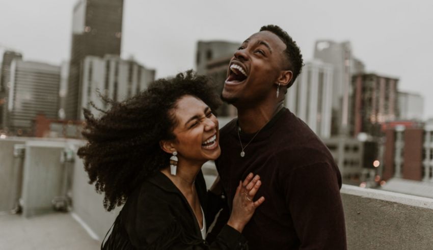 An african american couple laughing on a rooftop in chicago.