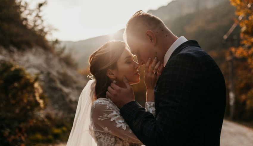 A bride and groom kissing on a mountain road in autumn.