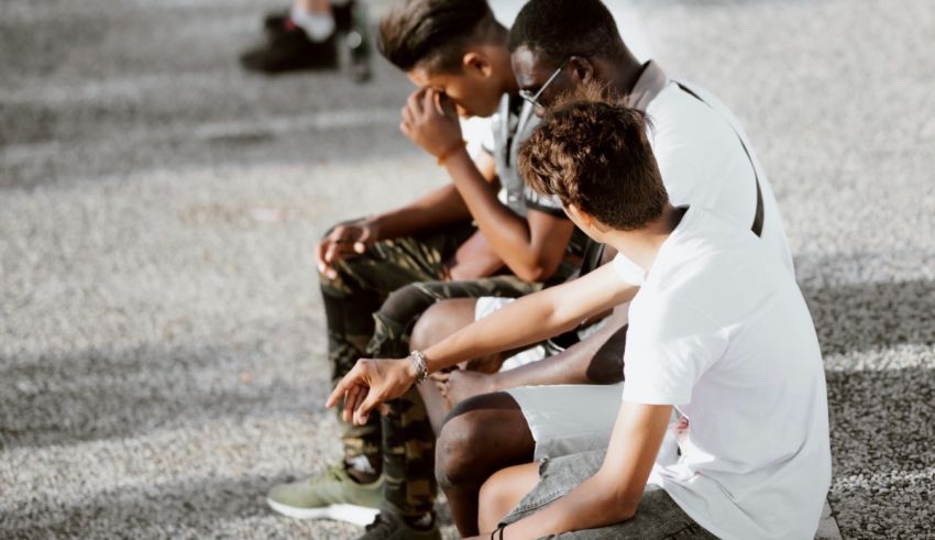 A group of young men sitting on the ground.