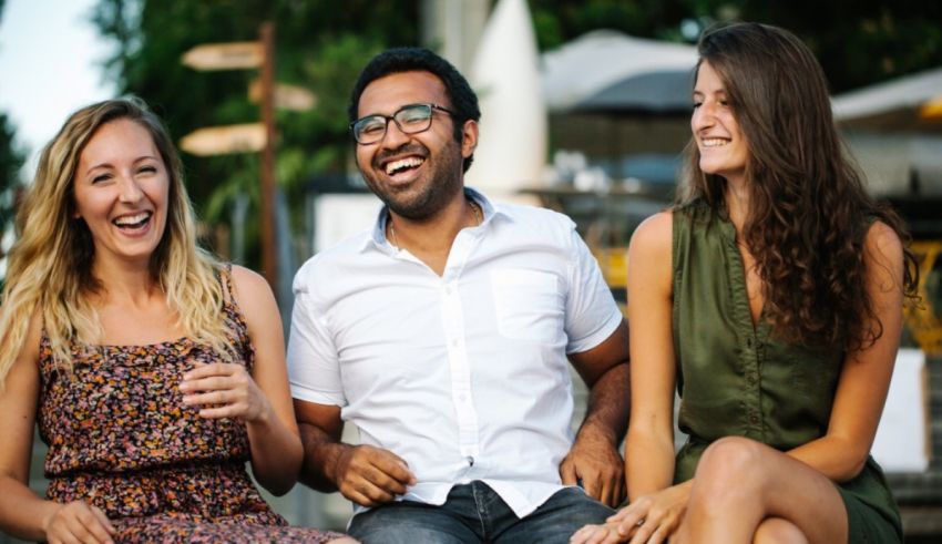 A group of friends laughing while sitting on a bench.