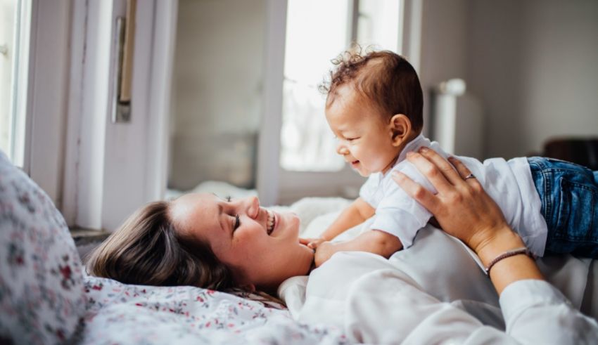 A woman laying on a bed with a baby in her arms.