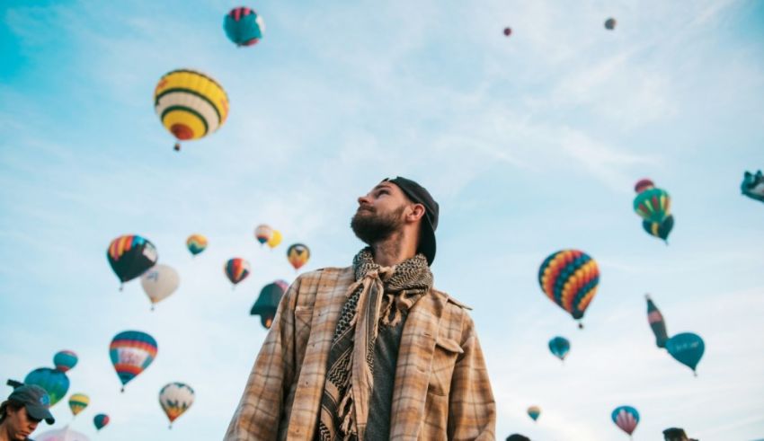A man standing in front of hot air balloons.