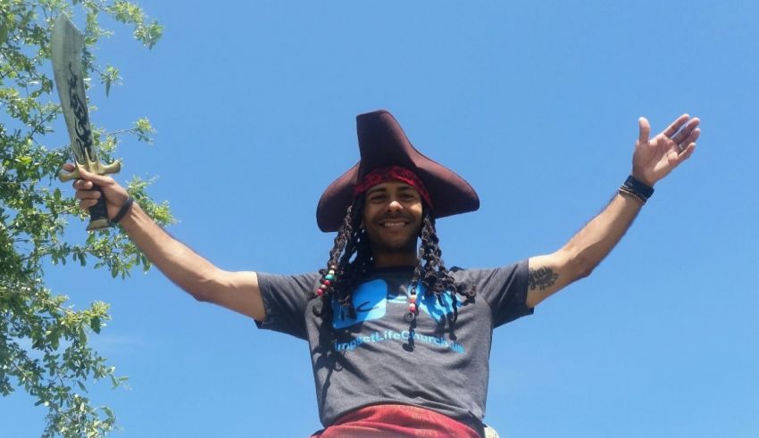 A man dressed as a pirate with his arms outstretched.