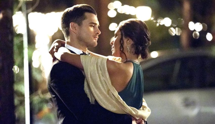 A man and woman hugging in front of a building at night.