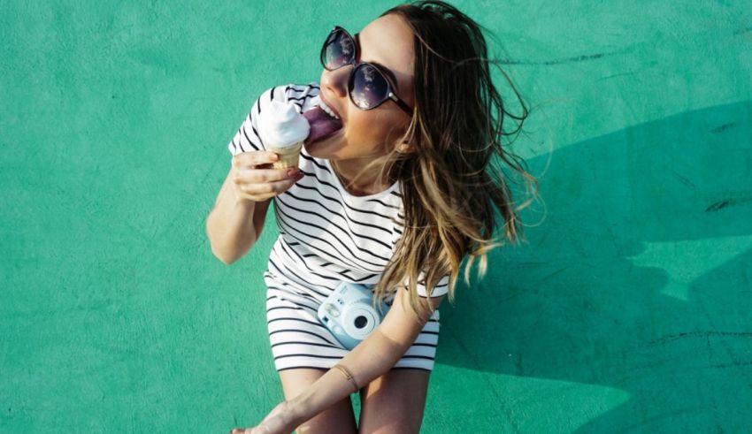 A woman is eating an ice cream cone on a green surface.