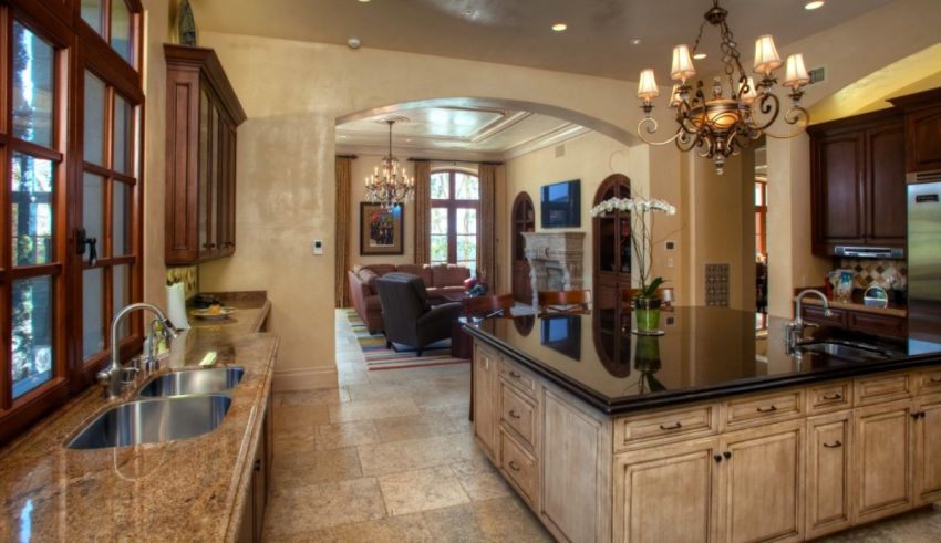 A large kitchen with marble counter tops and a chandelier.