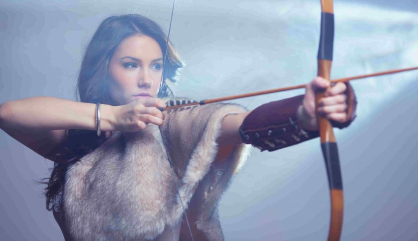 A woman is holding a bow and arrow.