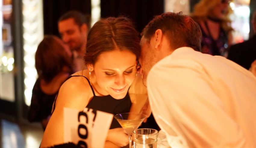 A man and woman kissing at a party.