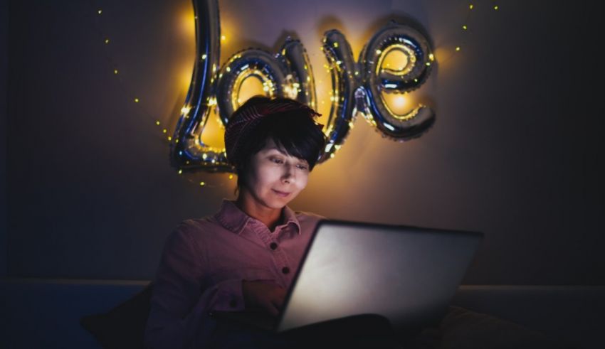 A woman is using a laptop with the word love on it.