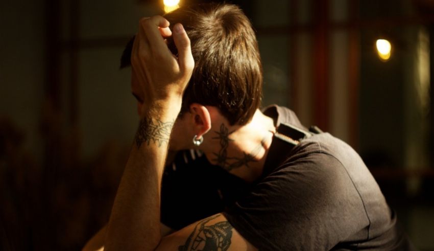 A man with tattoos sitting at a table.