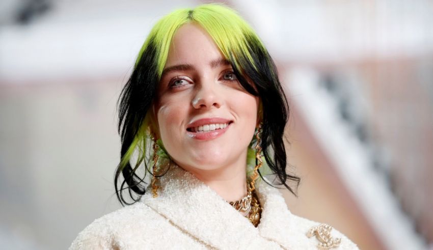 A woman with bright green hair is smiling.