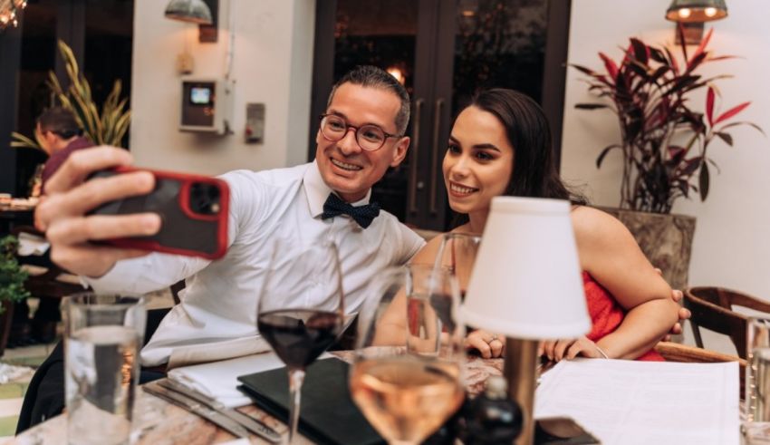 A man and woman taking a selfie at a restaurant.