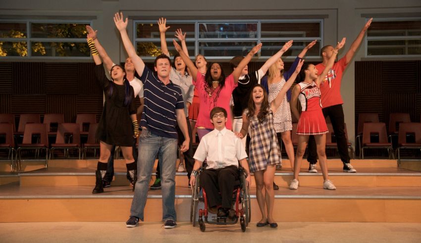 A group of people standing on a stage with their arms raised.