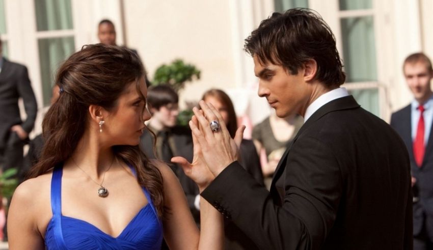 A man and woman in a blue dress standing next to each other.