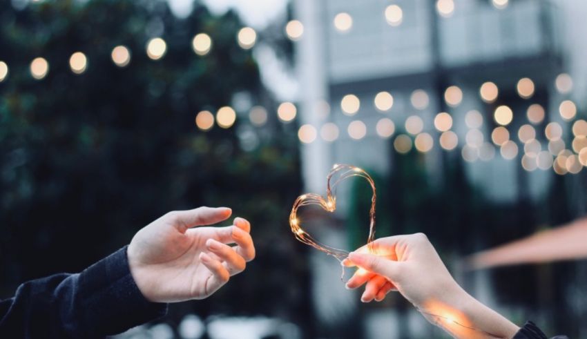 Two people holding a heart shaped sparkler in their hands.