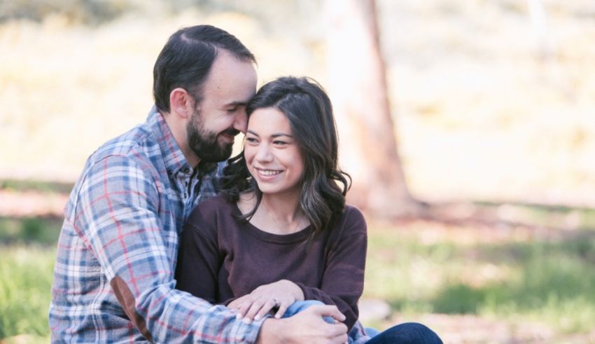 A couple embracing in a park during their engagement session.