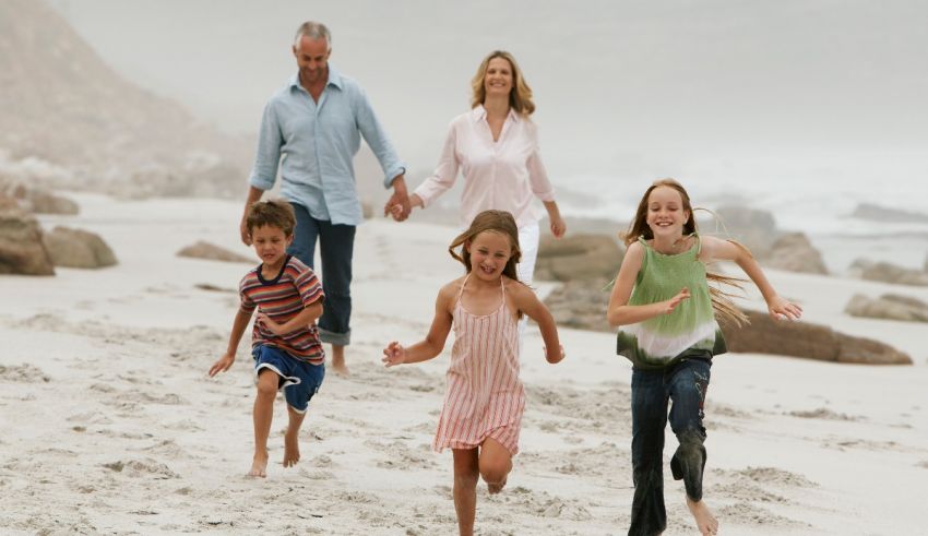 A family running on the beach.