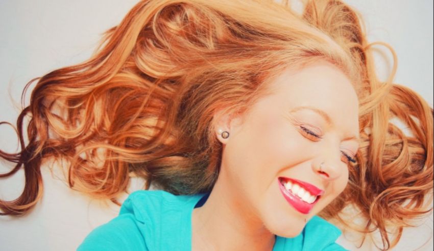 A woman smiling with her hair blowing in the air.