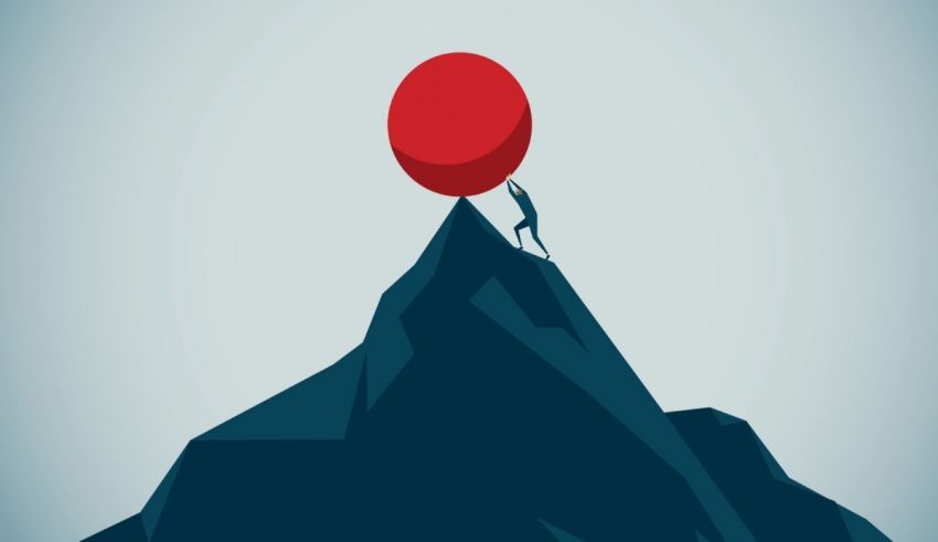 A man holding a red ball on top of a mountain.