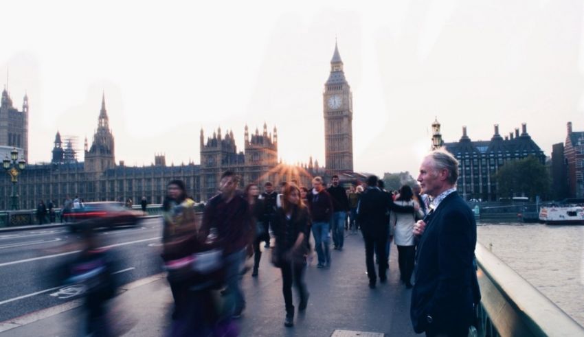 A group of people walking across a bridge in london.