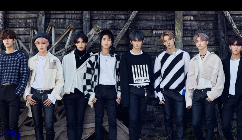 A group of korean boys standing in front of a wooden wall.