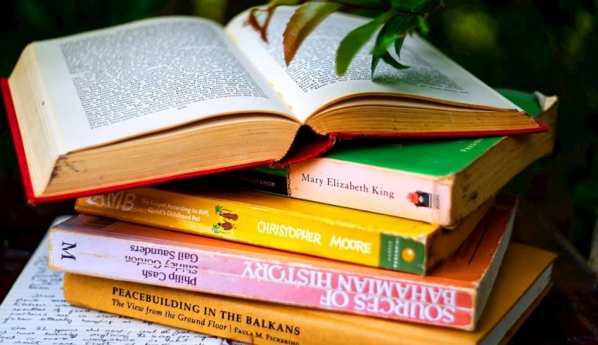 A stack of books with a book open on top.