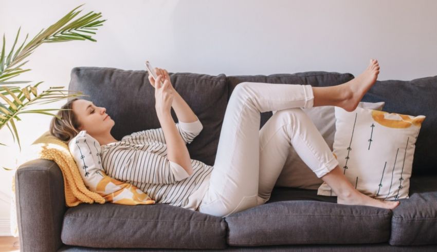 A woman relaxing on a couch with her feet up.