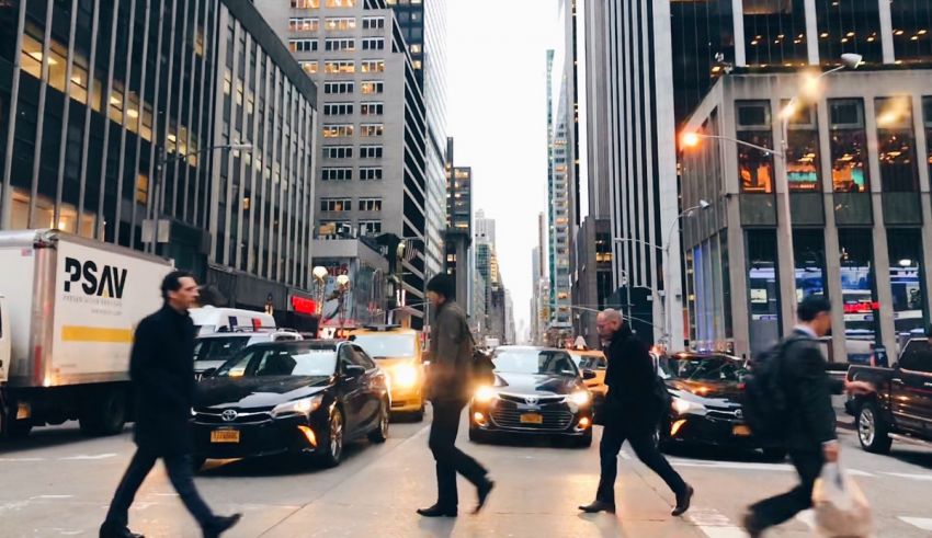 A group of people crossing a busy street in new york city.